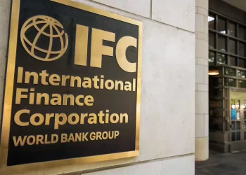 Gold-framed sign on a stone wall reading 'IFC International Finance Corporation World Bank Group' with a globe logo, outside a office building.